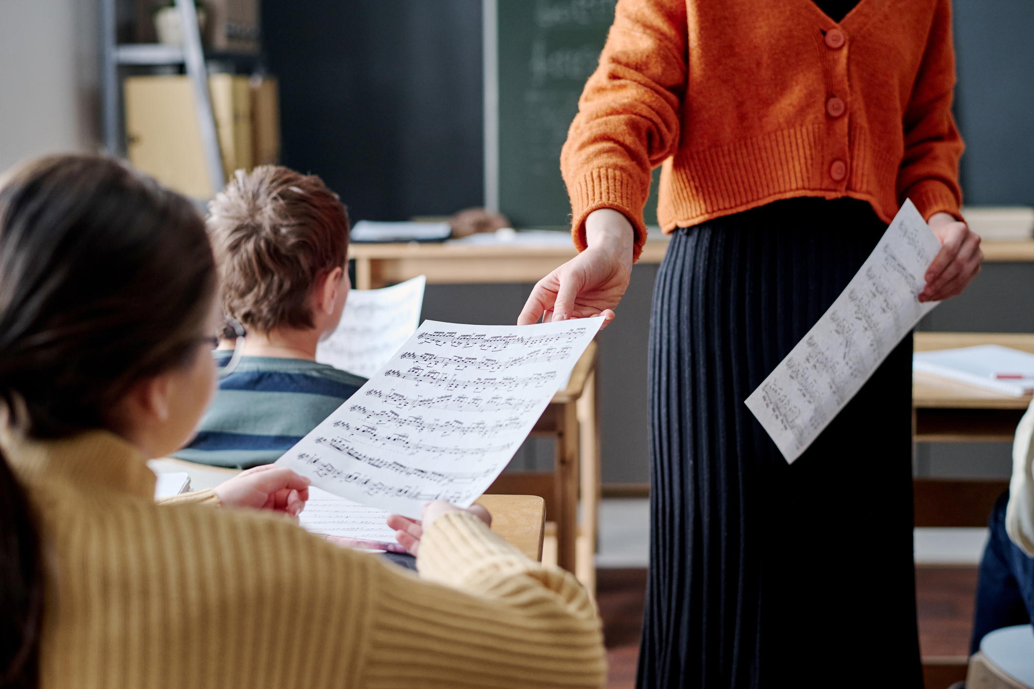  Teacher Spreading Sheet Music During Lesson