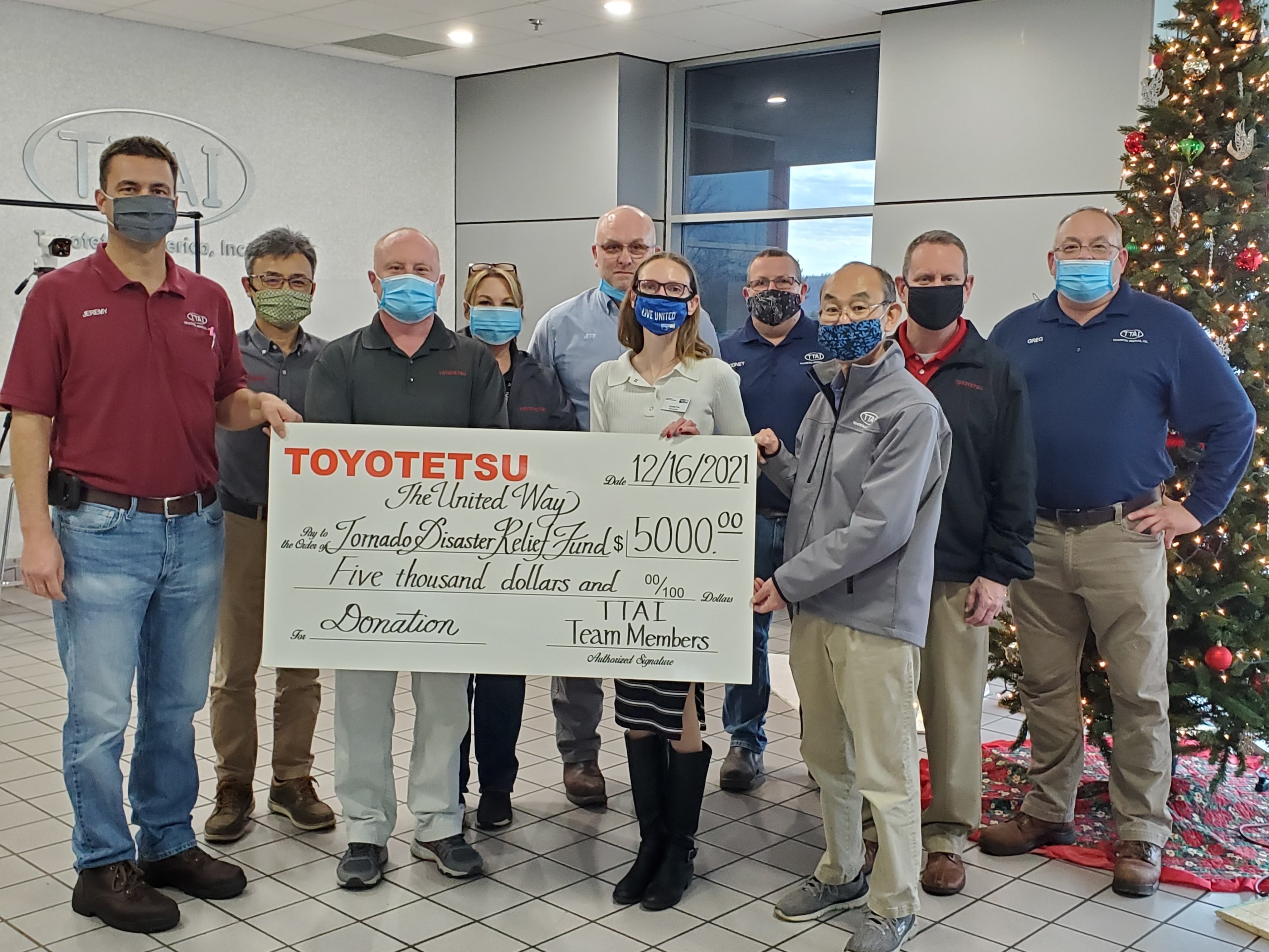 Group photo of Toyotetsu staff and Crystal with large check.