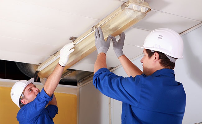 Two Electrician Repairing Office Lighting