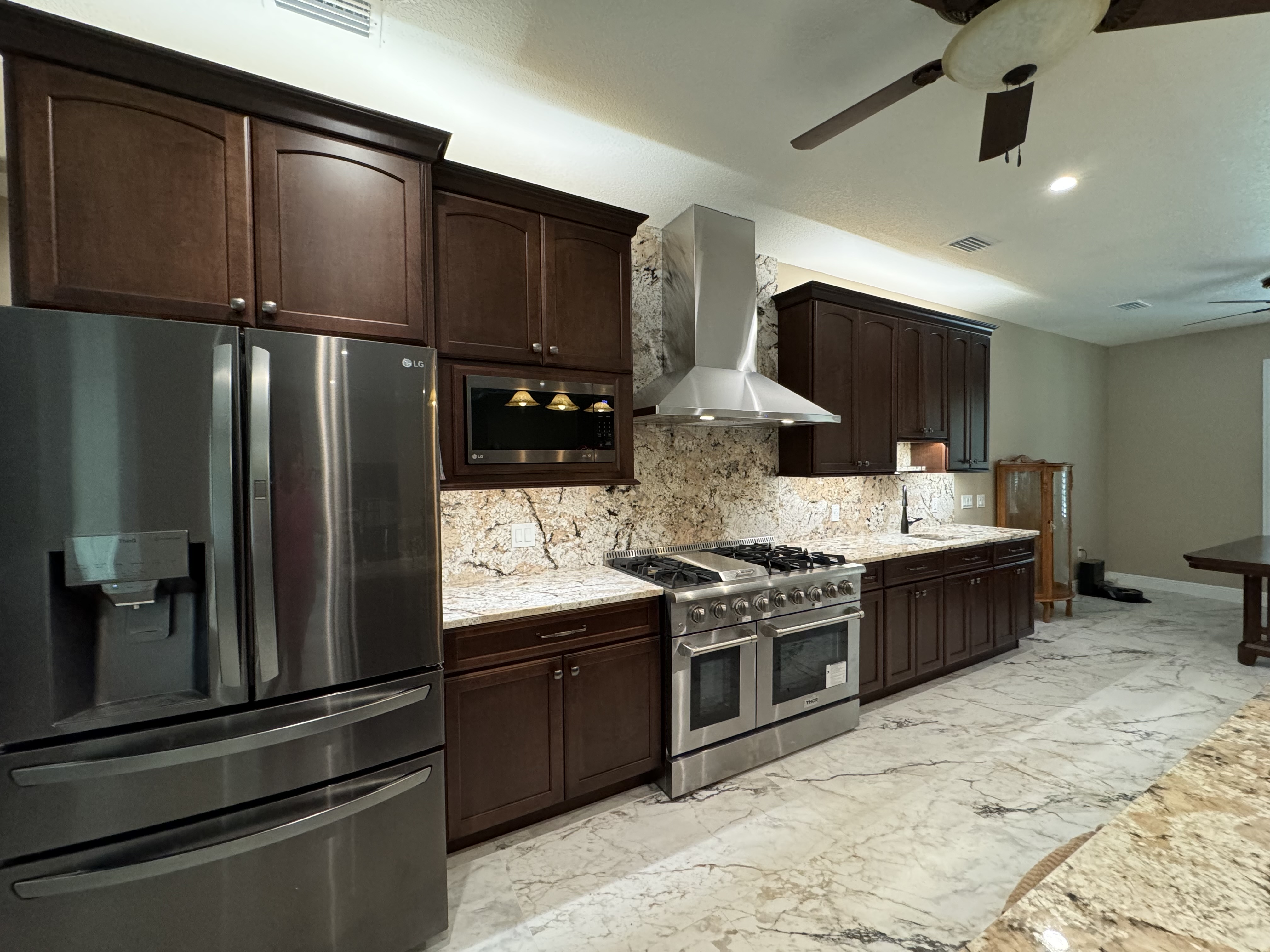 The under-cabinet lighting illuminates the stunning full-scale granite backsplash. 