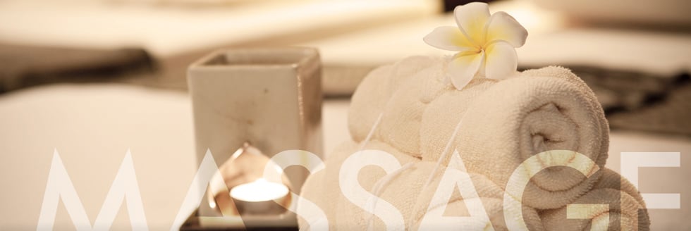 Luxurious spa interior with a modern freestanding bathtub, elegant decor, and 'Arina's Massage Therapy' sign on the wall.