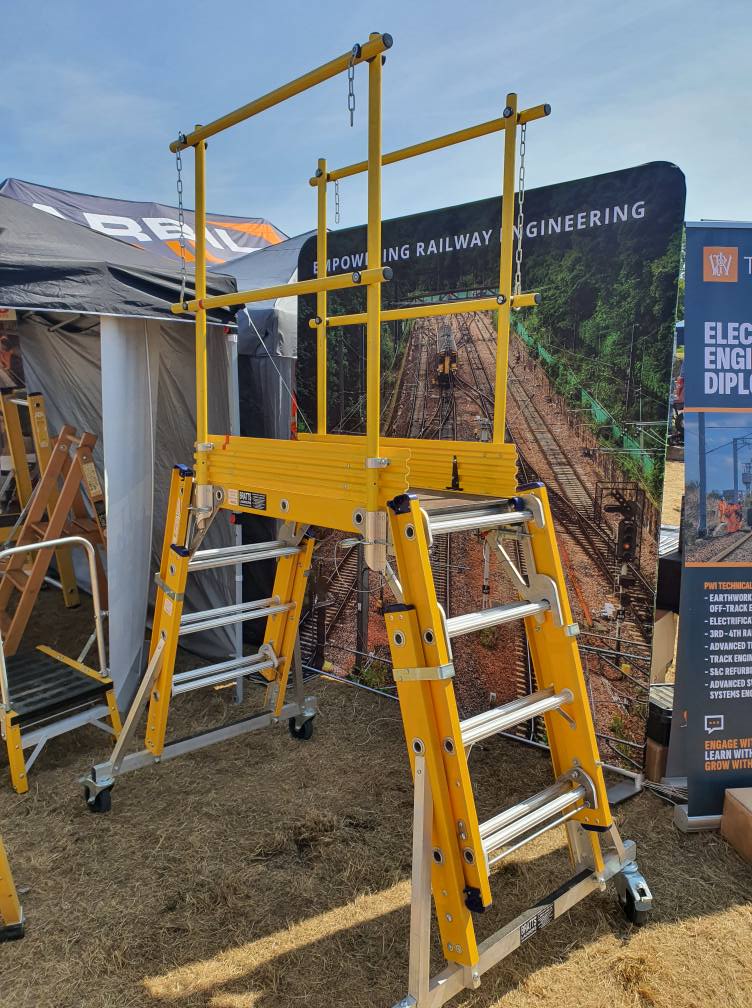 Scaffolding setup in a control room with multiple monitors and office furniture, showcasing a work-in-progress environment.