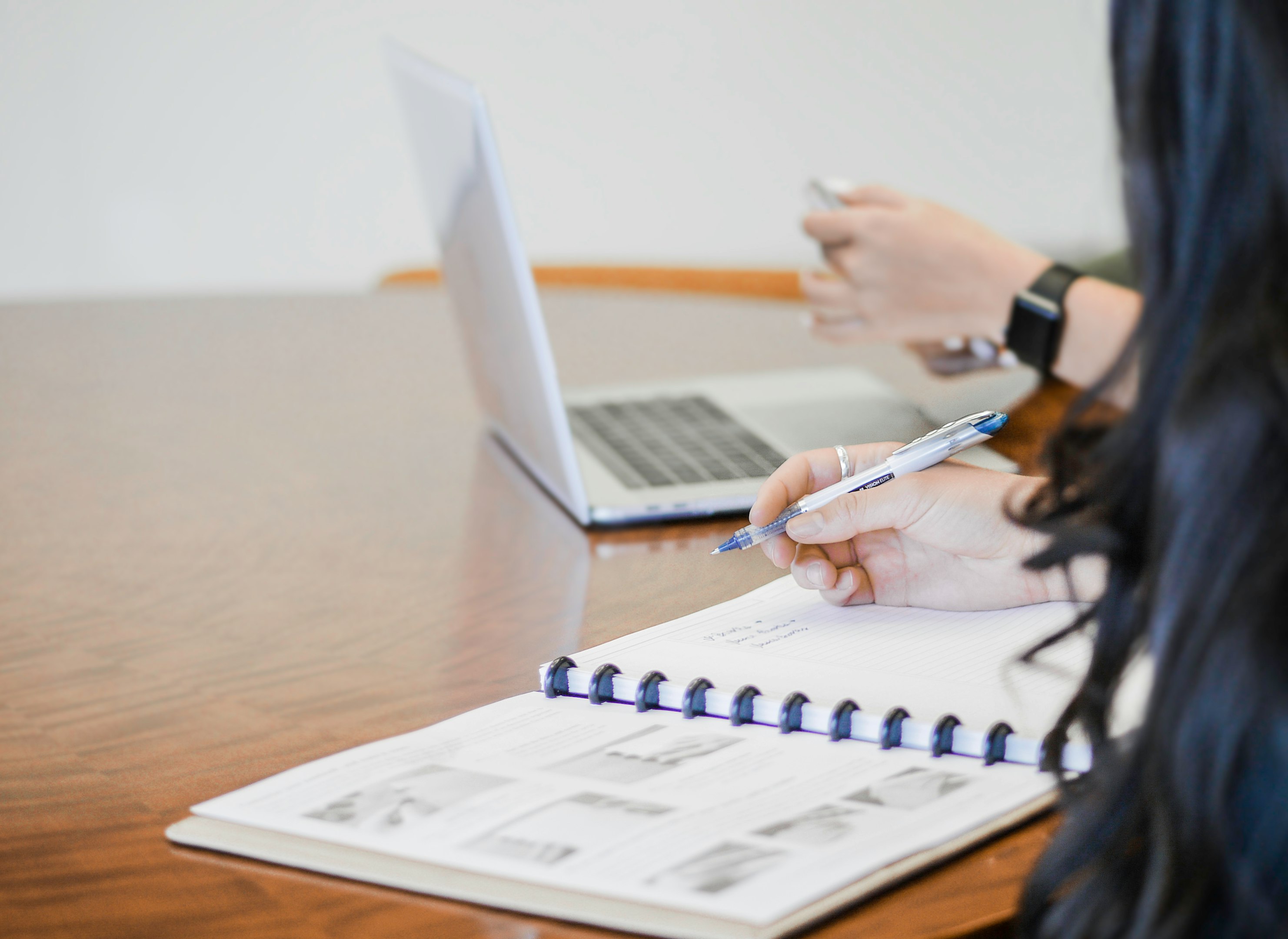 person holding pen writing on paper
