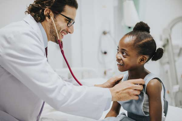 Friendly pediatrician Checking a Little Girls Heart