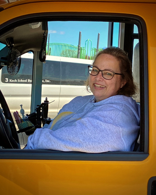 Beth started in 2010 driving vans, then switched to a mini bus. She is licensed for driving big buses but just loves driving the “little buses”. Beth has driven routes for Watertown, Waconia and Chaska and currently drives pre-school and SPED students.
She loves the relationships she’s made with “her kids” and their families. Beth has driven some of her kids since pre-school and many are now in middle school. She says everyday is different and every child makes her smile!
When she’s not driving, Beth loves spending time with her own kids & grandkids. She also likes the theater, reading, sewing / crocheting and recently started painting.