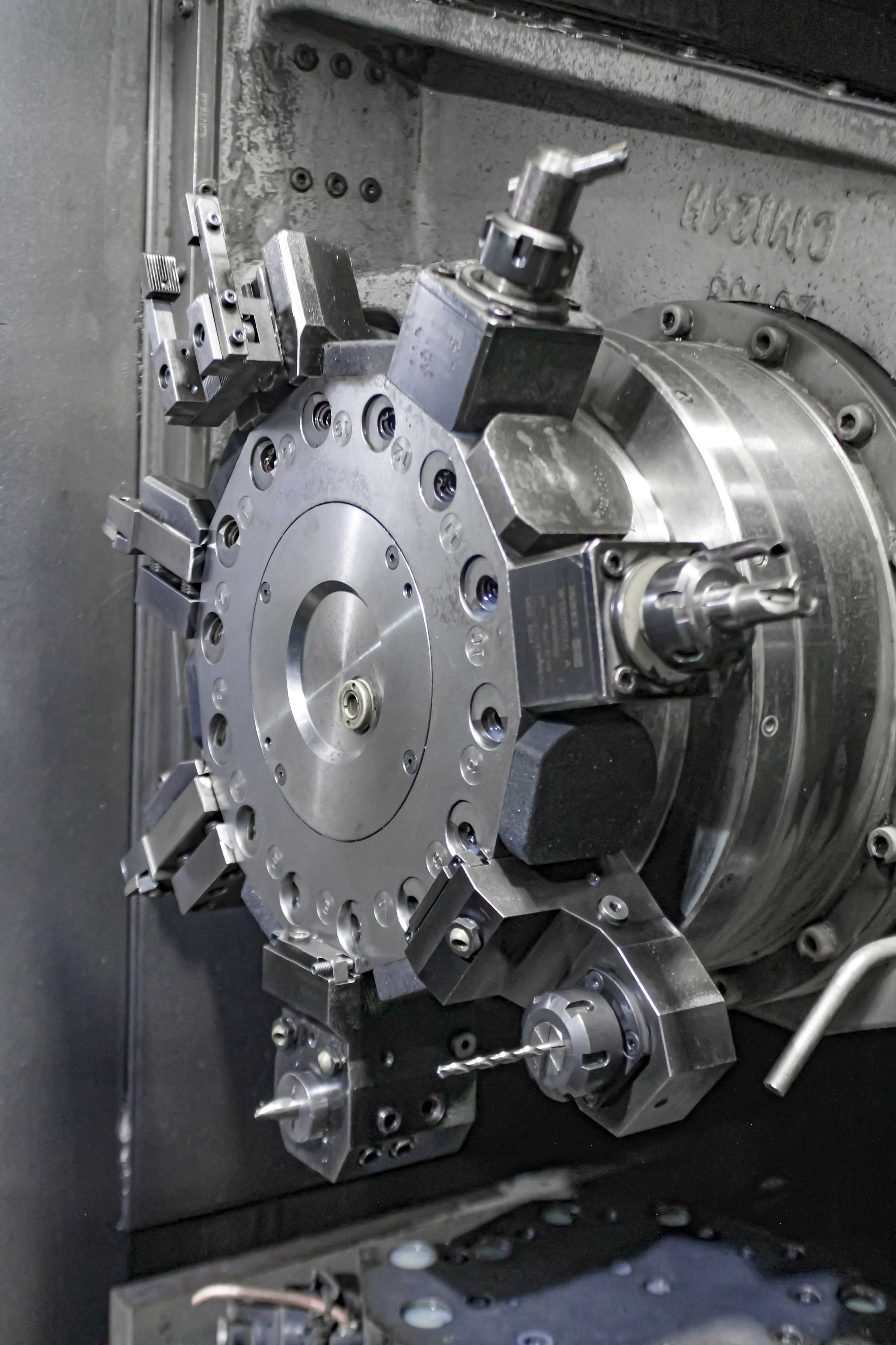 Primer plano de una máquina CNC, mostrando un cabezal de herramientas giratorio con varios portaherramientas. Primer plano de una máquina CNC, mostrando un cabezal de herramientas giratorio con varios portaherramientas.