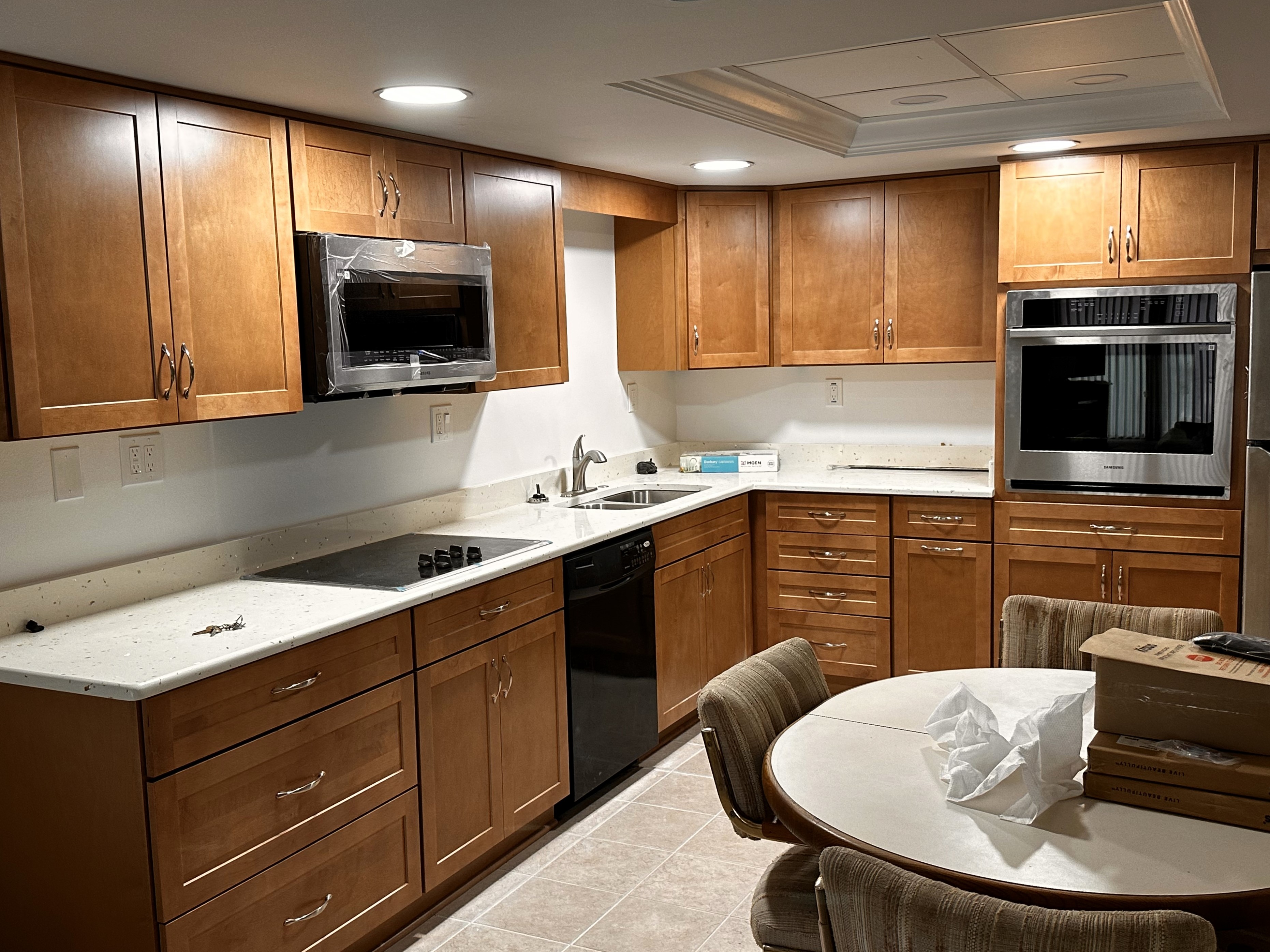 Timeless kitchen featuring maple-stained semi-custom cabinetry, Sunny Pearl Pompeii quartz with matching 4" backsplash, and satin nickel hardware.