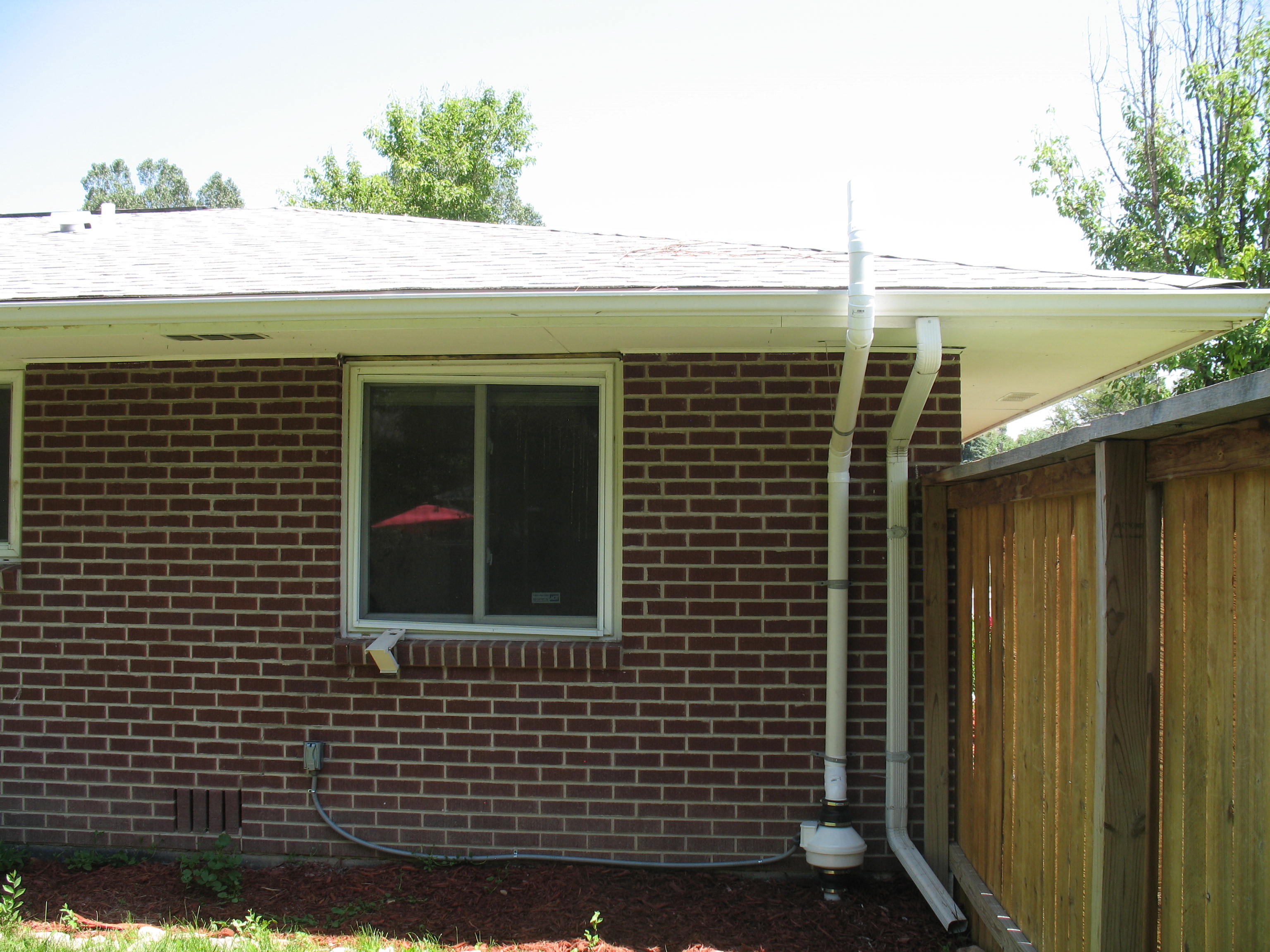 Outdoor system piped parallel to downspout