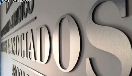 Letras metálicas en relieve sobre pared, rótulo corporativo de oficina con diseño moderno