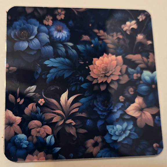 Square metal coaster with a floral design