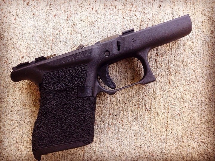 Small grame Glock with a double undercut triggerguard and full wrap medium stippling.