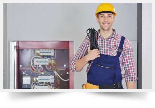 Young Electrician with Tools Standing Near Open Distribution Board