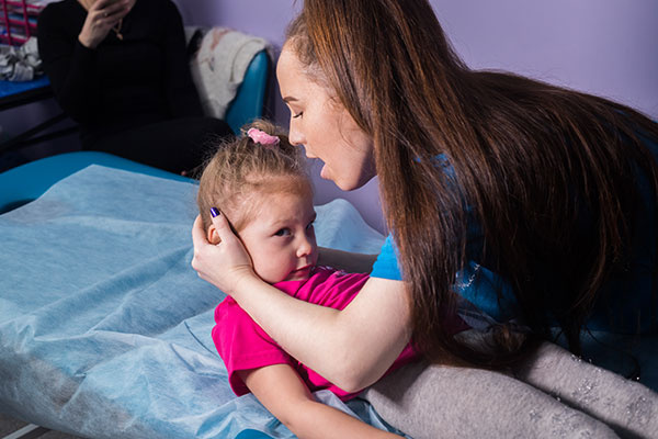 Physiotherapy with a baby having a cerebral palsy.