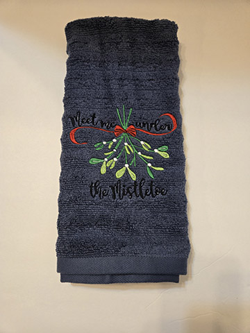 Dark blue hand towel featuring a mistletoe design