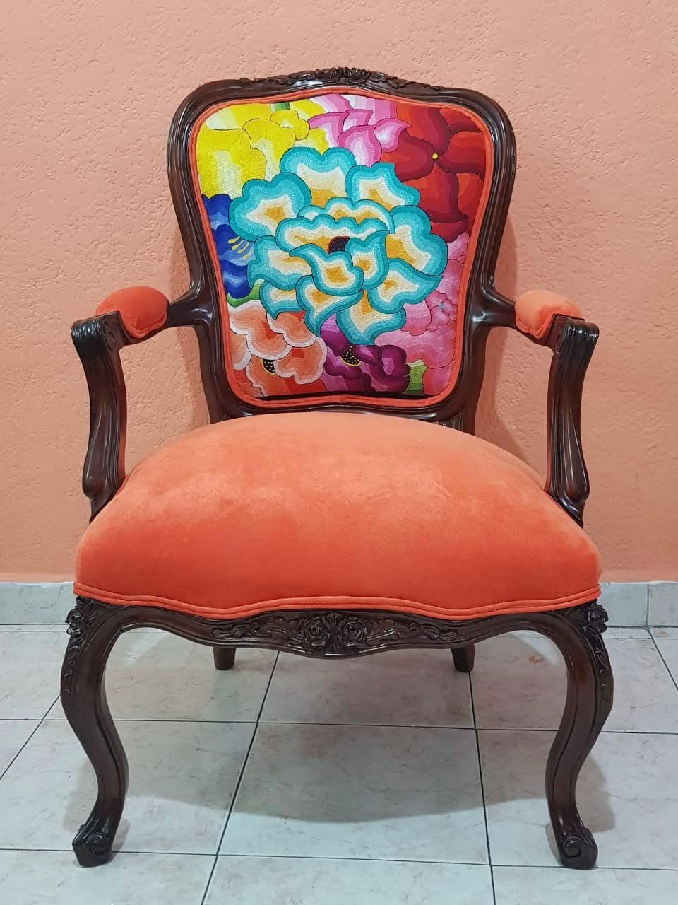 Modern living room with white sectional sofa, brown pillows, a round wooden coffee table, large plant, and a desert landscape painting on wooden wall.