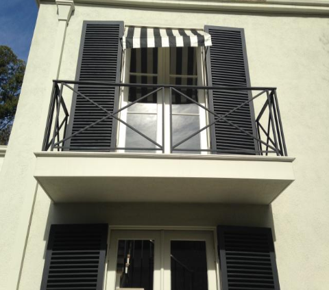 Wrought iron balcony off a staccato building.