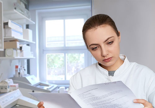 Young female scientist reading printed notes