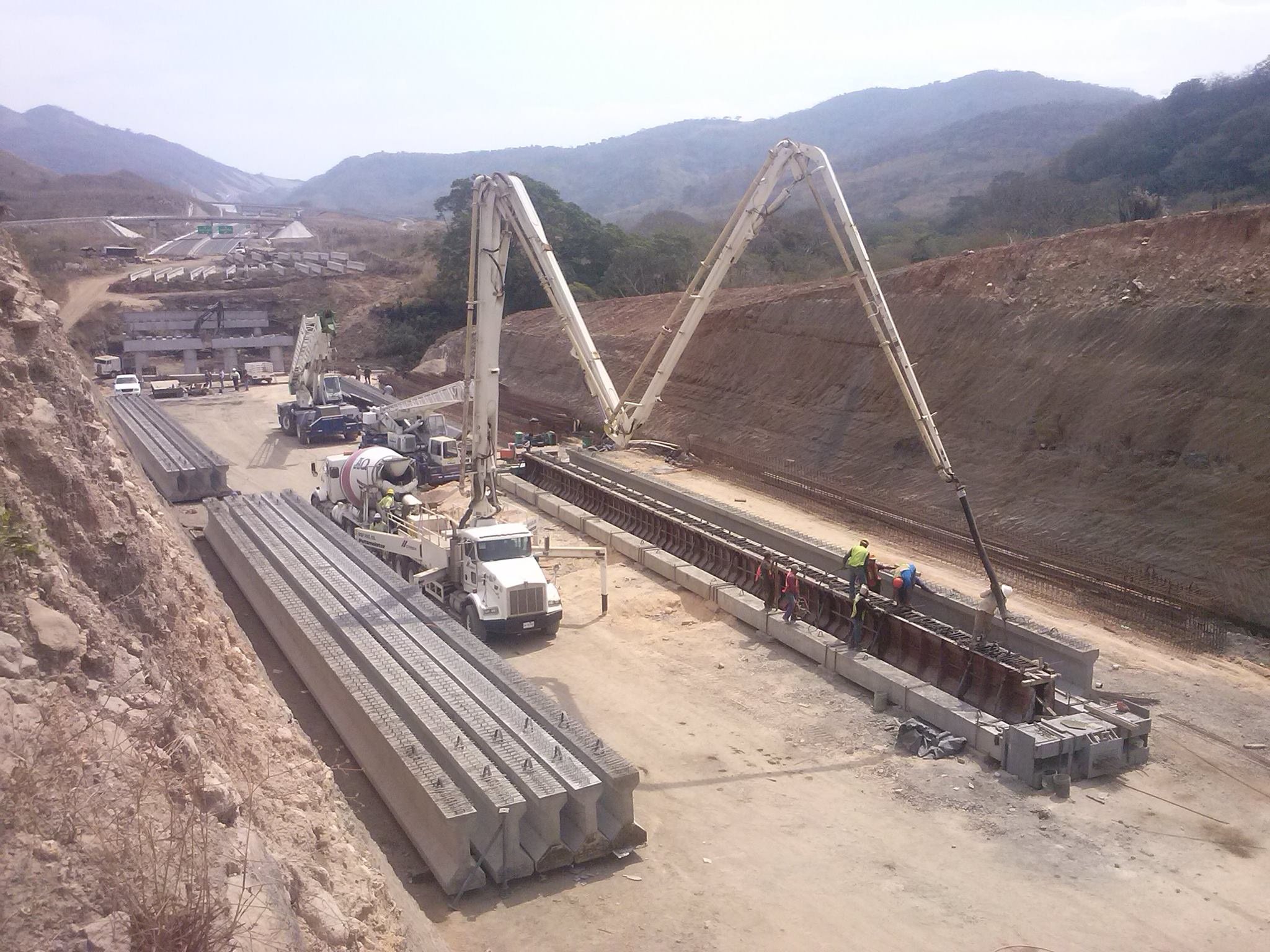 Construcción de un puente en una zona montañosa con maquinaria pesada y trabajadores. Construcción de un puente en una zona montañosa con maquinaria pesada y trabajadores.