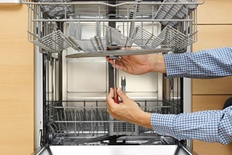 Handyman Repairing A Dishwasher