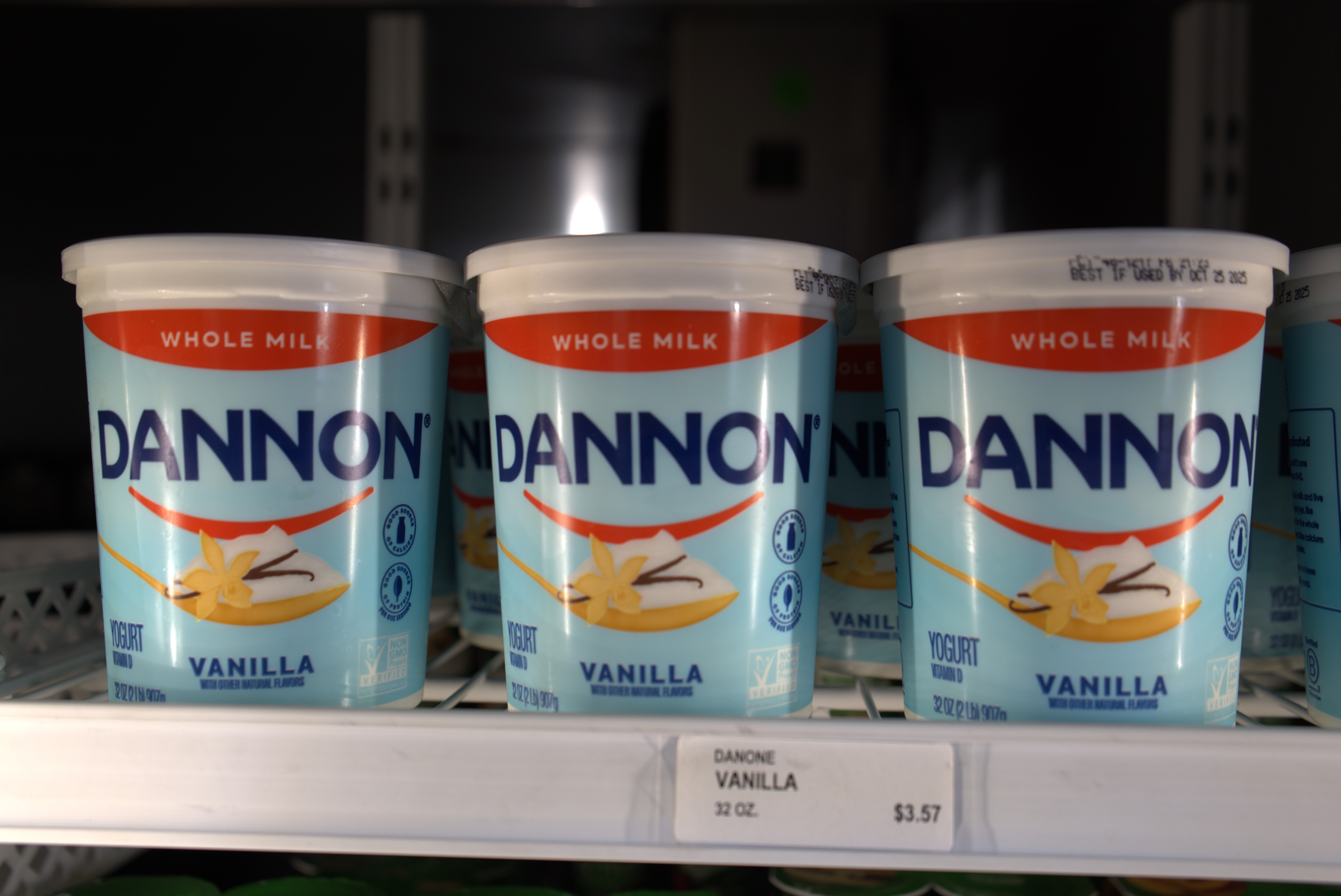 Basket with fruits and juice bottles on a grocery store shelf.