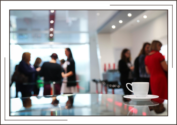 Coffee cup on a table with a blurred background with some women in it