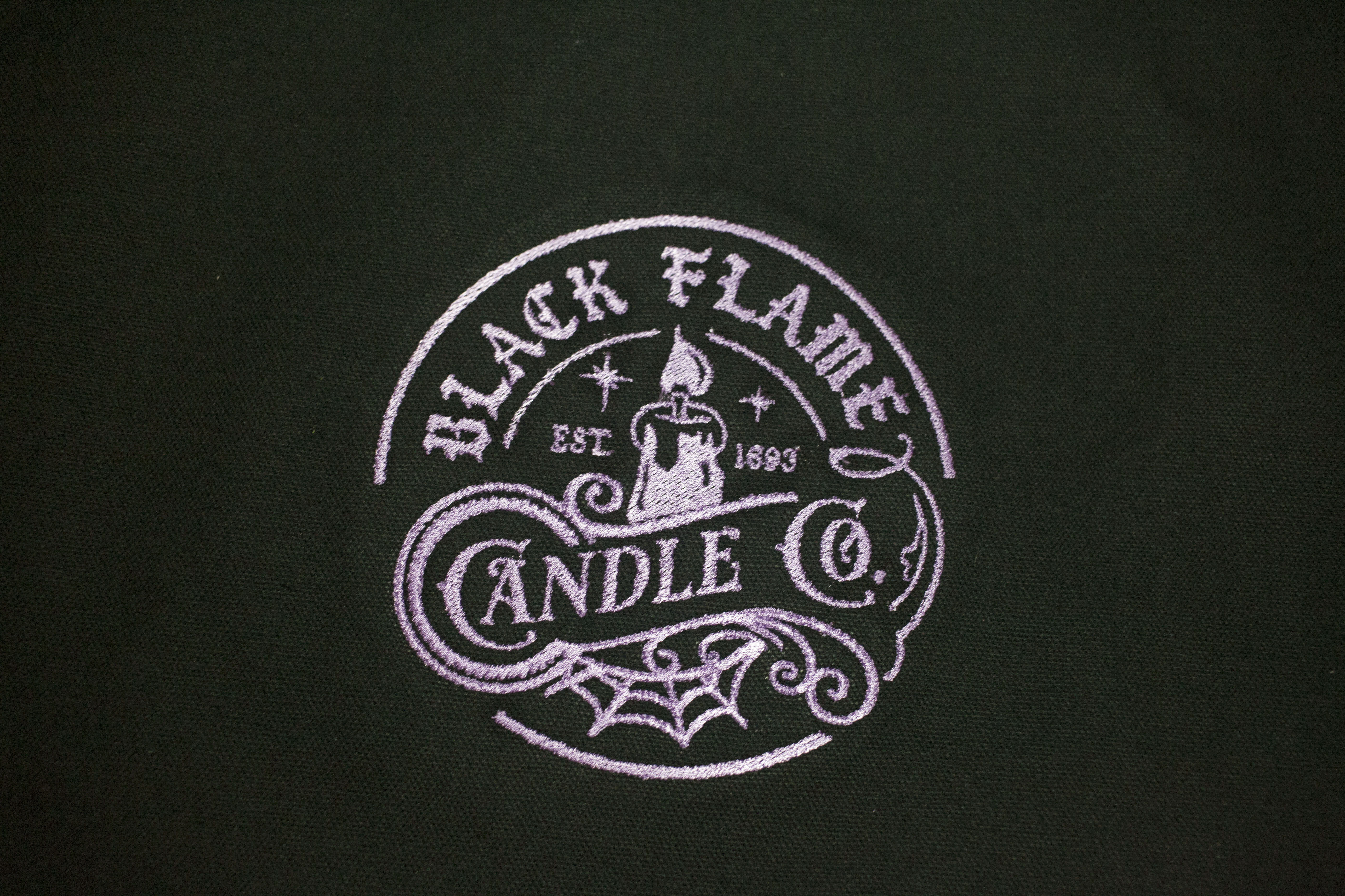  Black tote bag with a black flame candle design