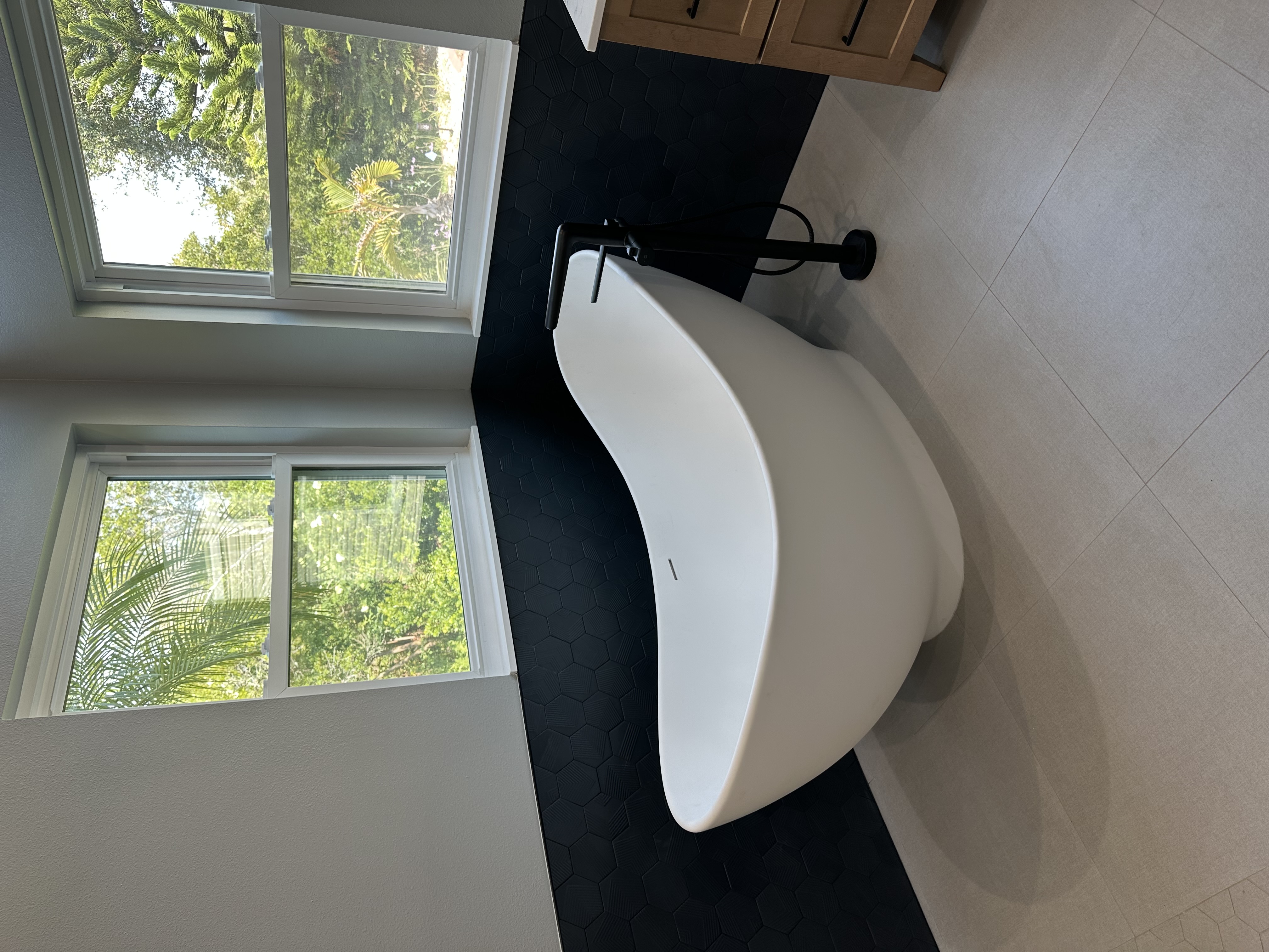 Indigo hexagon tiles wrap the surrounding tub walls, making this large freestanding tub the perfect place to unwind and recharge after a long day.