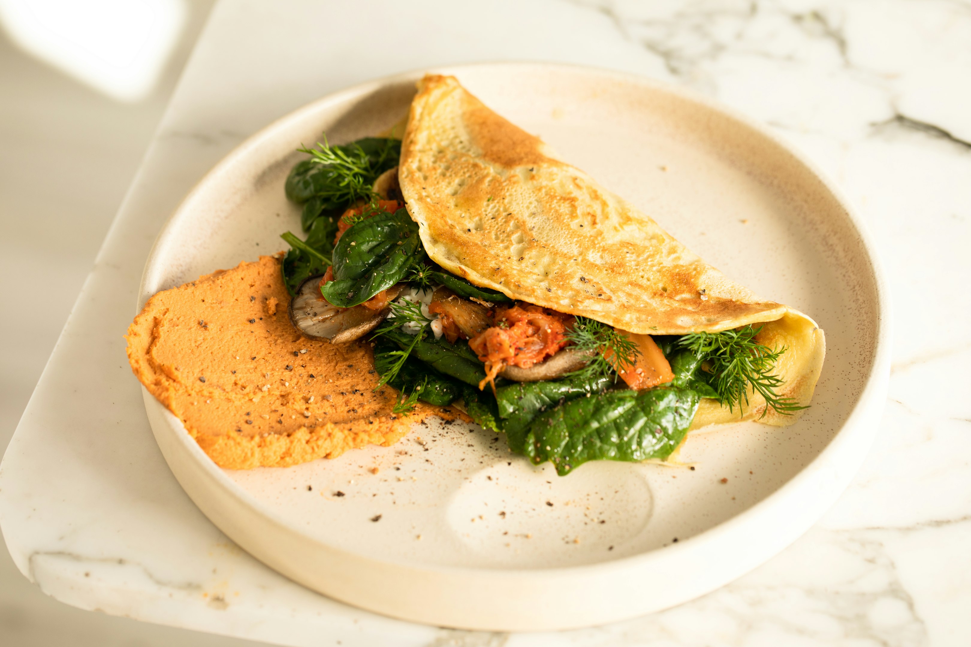 un plato blanco coronado con una tortilla y verduras