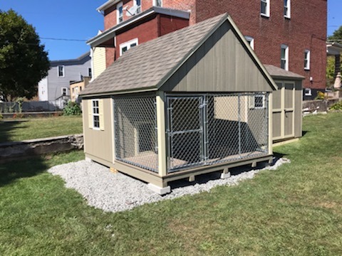 10 x 12 Dog Kennel                    
                                                             
 Featuring clay colored wood siding (Duratemp T-1-11), Beige colored trim, and weatherwood 30 year architectural shingles. Beige colored shutters.                                          
Standard features include: your choice of color combinations Pressure treated floor joists, composite decking, 3’ rear entry door, 2- 18”x27” slider windows with screens, gable vents, doggy door, 3’ Chainlink gate.