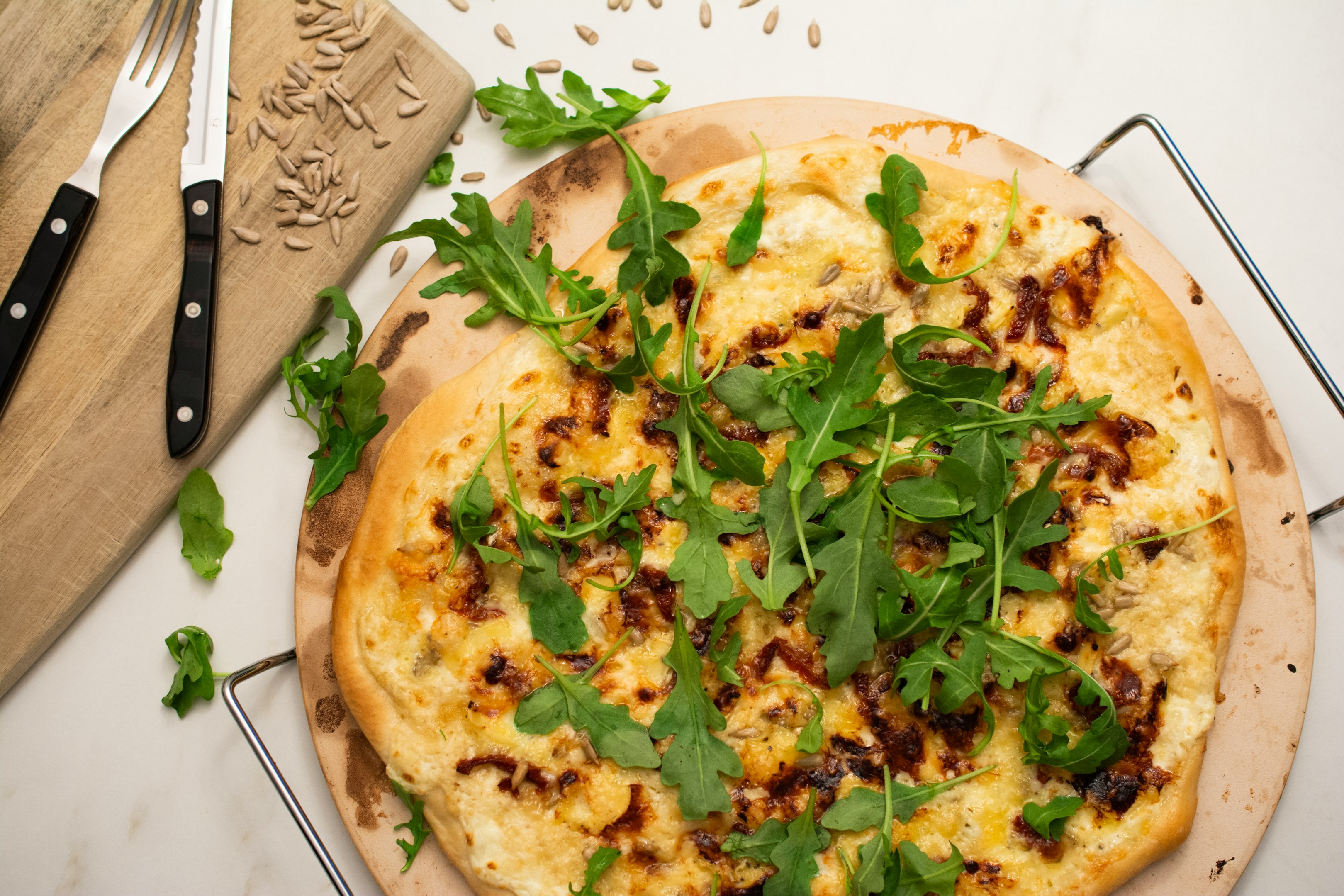 una pizza sobre una tabla de cortar de madera