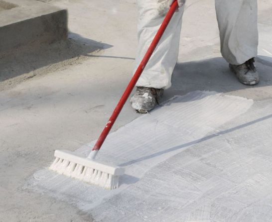 Trabajadores impermeabilizando techos y terrazas con sellador en cubierta metálica y superficie de concreto
