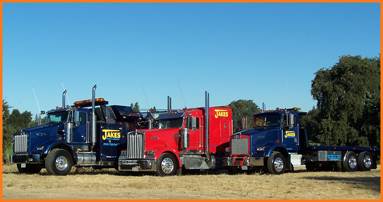 Three tow trucks parked beside each other||||