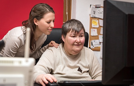 Caregiver and Mentally Disabled Woman Learn at the Computer