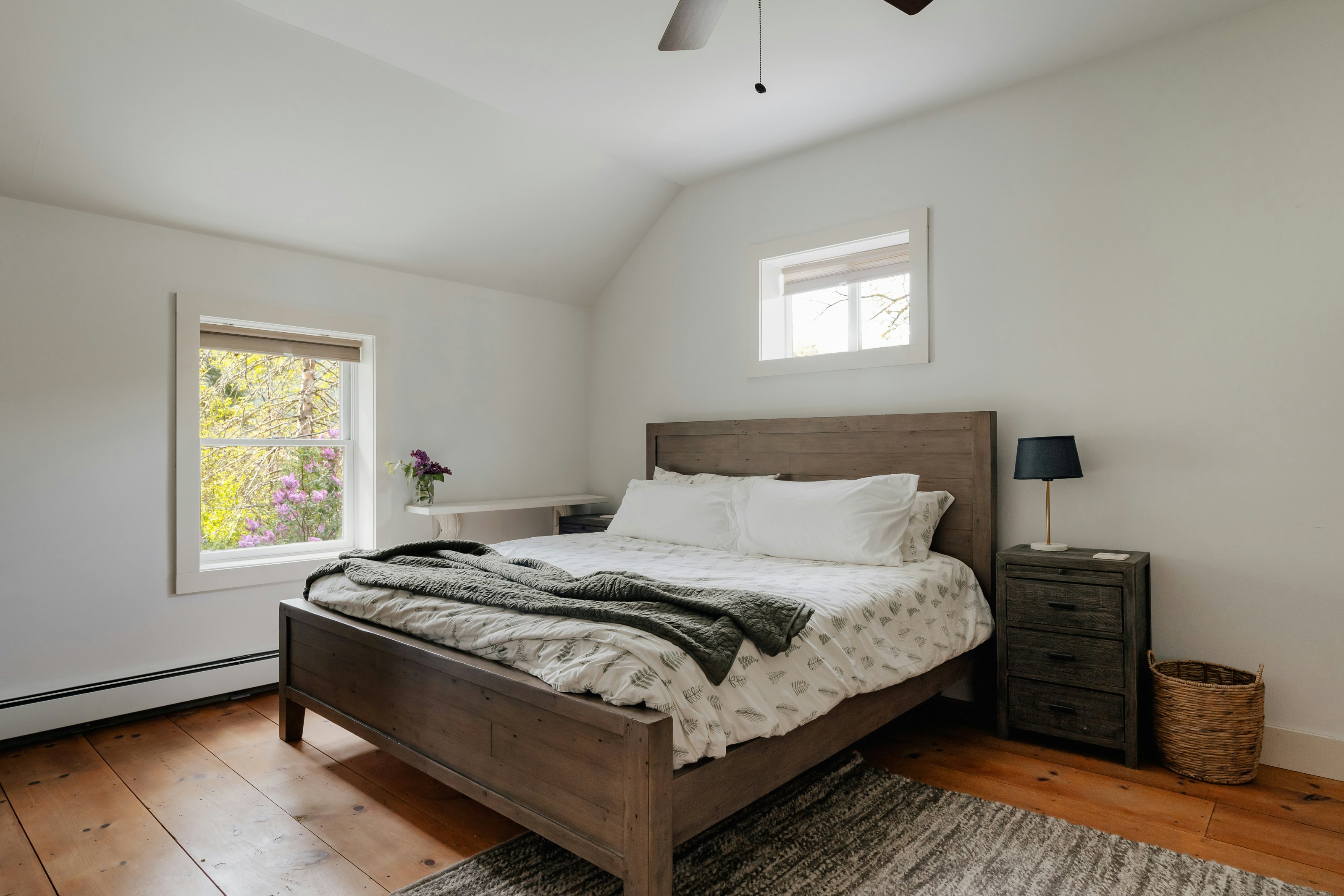 a bed sitting in a bedroom next to a window