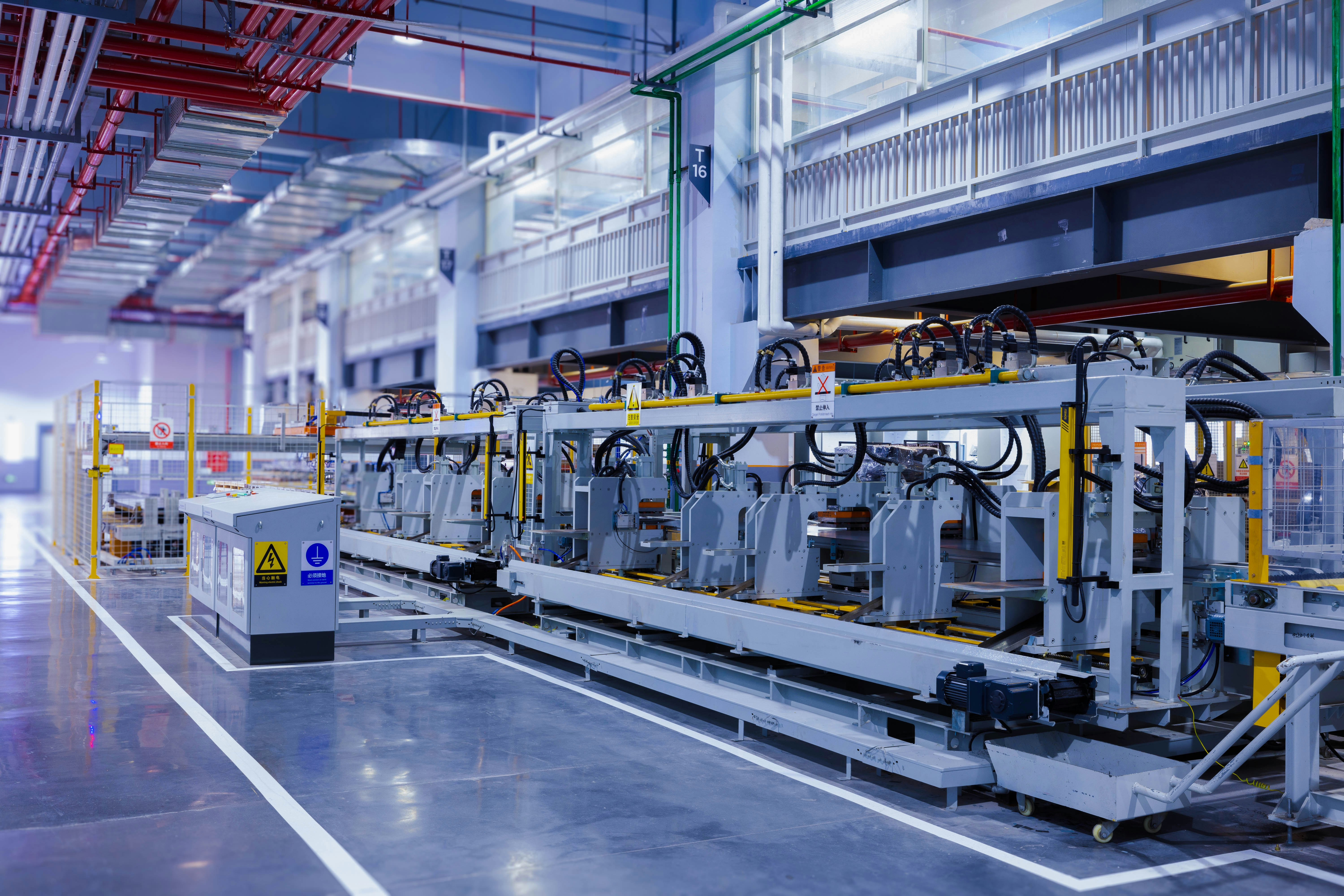 Línea de producción automatizada en una fábrica moderna con maquinaria industrial y sistemas de tuberías. Línea de producción automatizada en una fábrica moderna con maquinaria industrial y sistemas de tuberías.