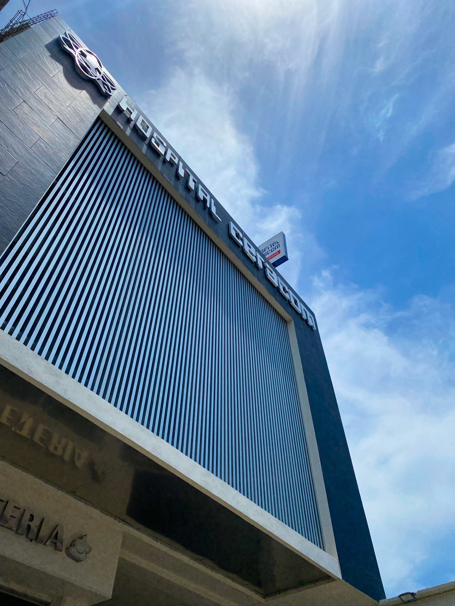 Fachada del Hospital CEMCA con cielo azul.