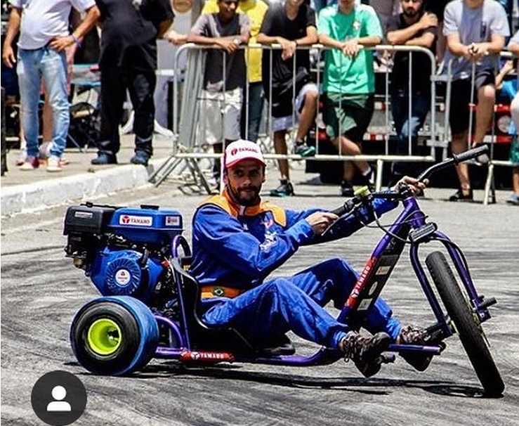 um carro dirigindo em uma pista de corrida com fumaça saindo dele