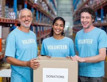 Volunteers Holding a Donations Box
