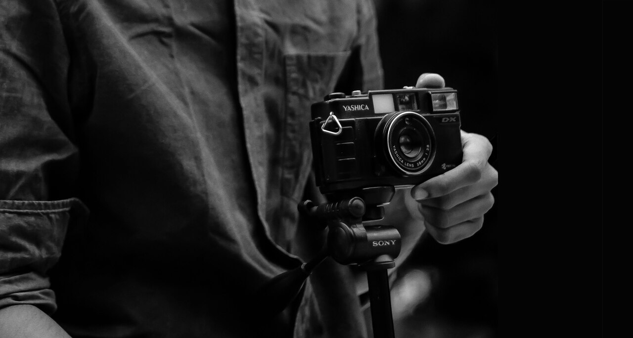 grayscale photo of person holding camera