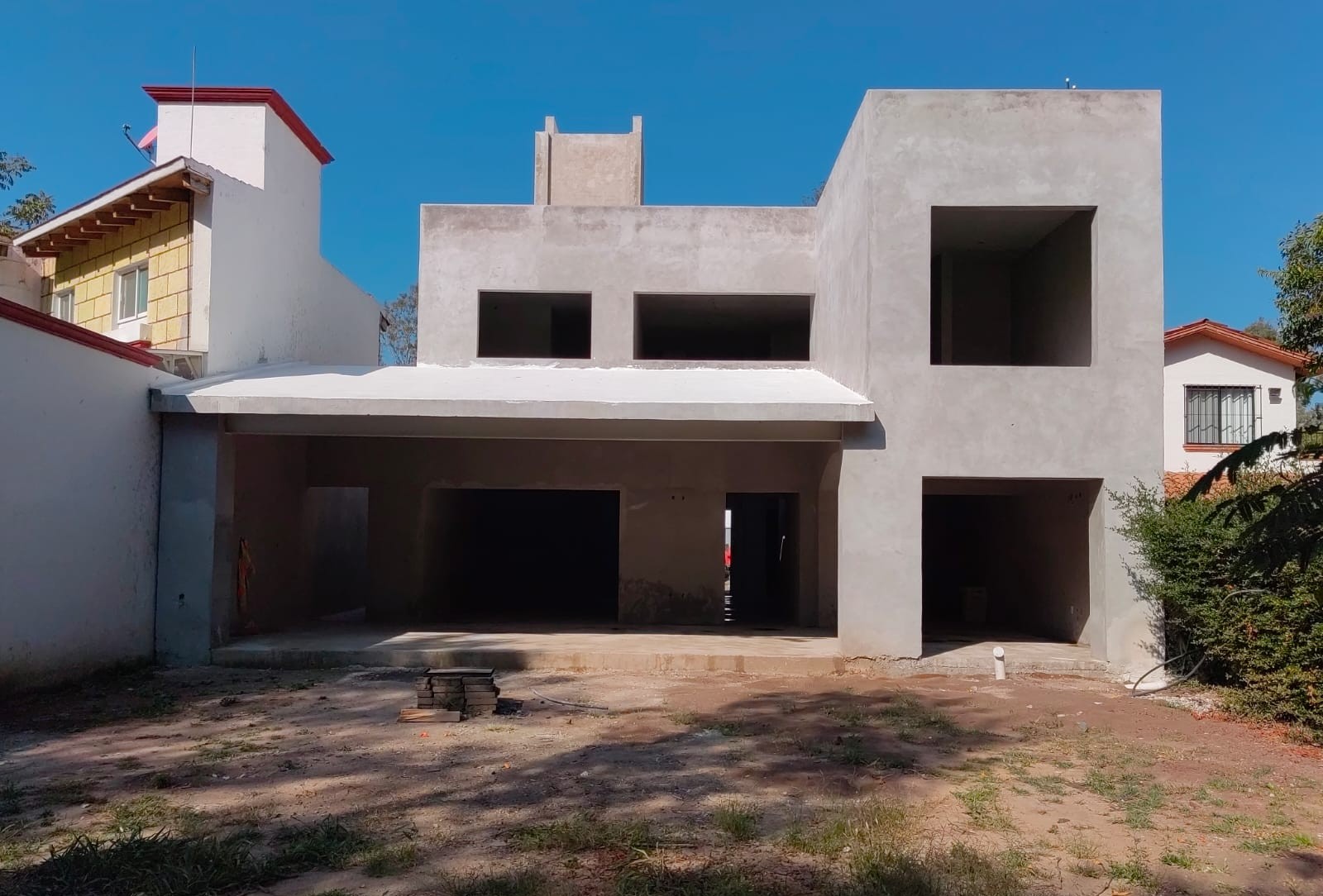 Dos personas trabajando en una cafetería, conversando y usando una laptop, con estanterías de libros al fondo.