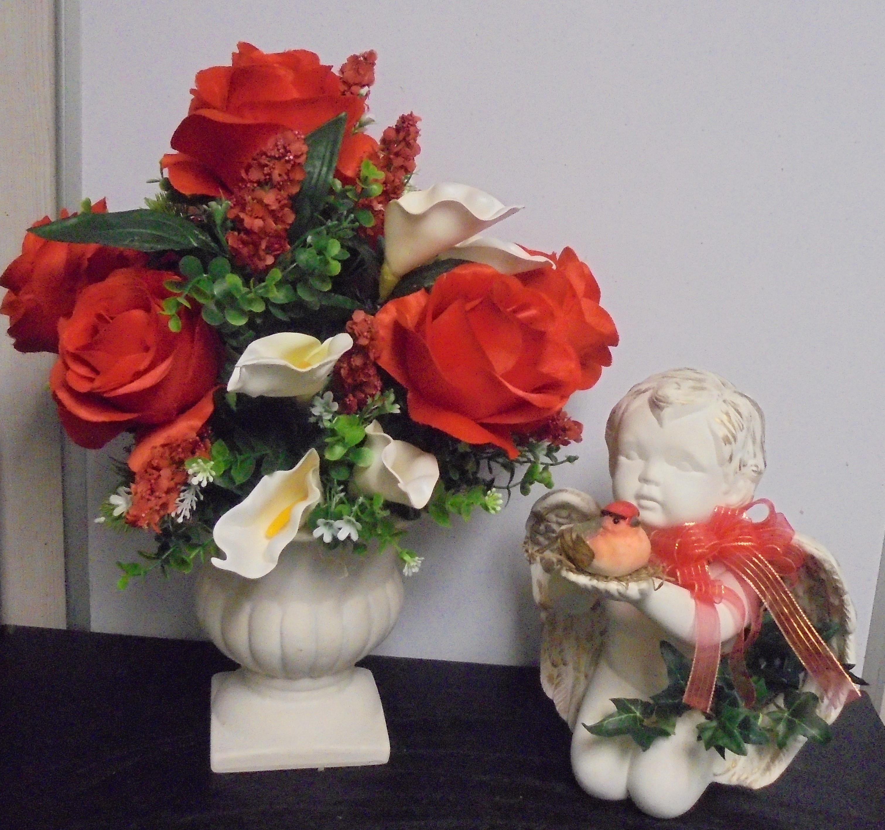 (53) "Silk" Vase Arrangement
(Red-Orange Roses) W/
Angel Holding Bird
(Plays Song-He's Got the Whole World)
$82.50