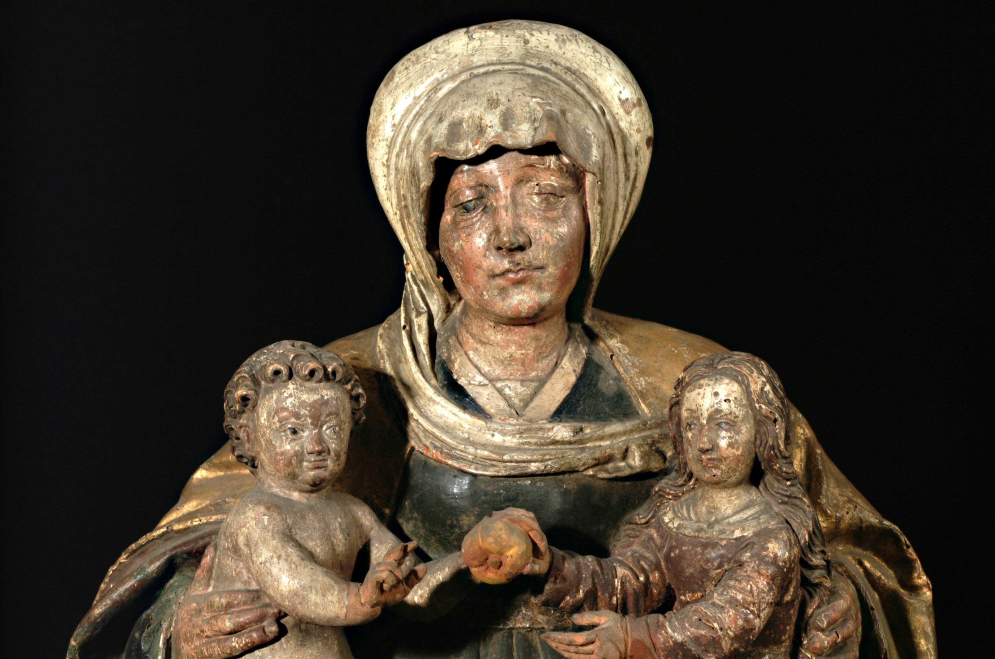 hombre en túnica marrón sosteniendo una estatua de bebé