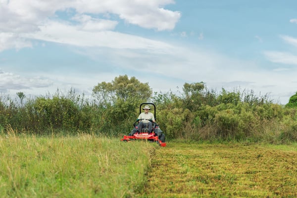 A Man Mowing a Farm Field