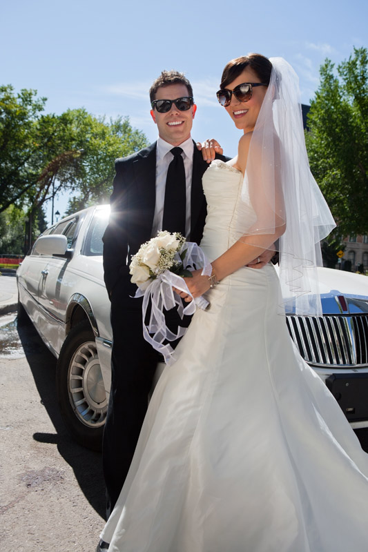 Newly married couple beside limousine||||