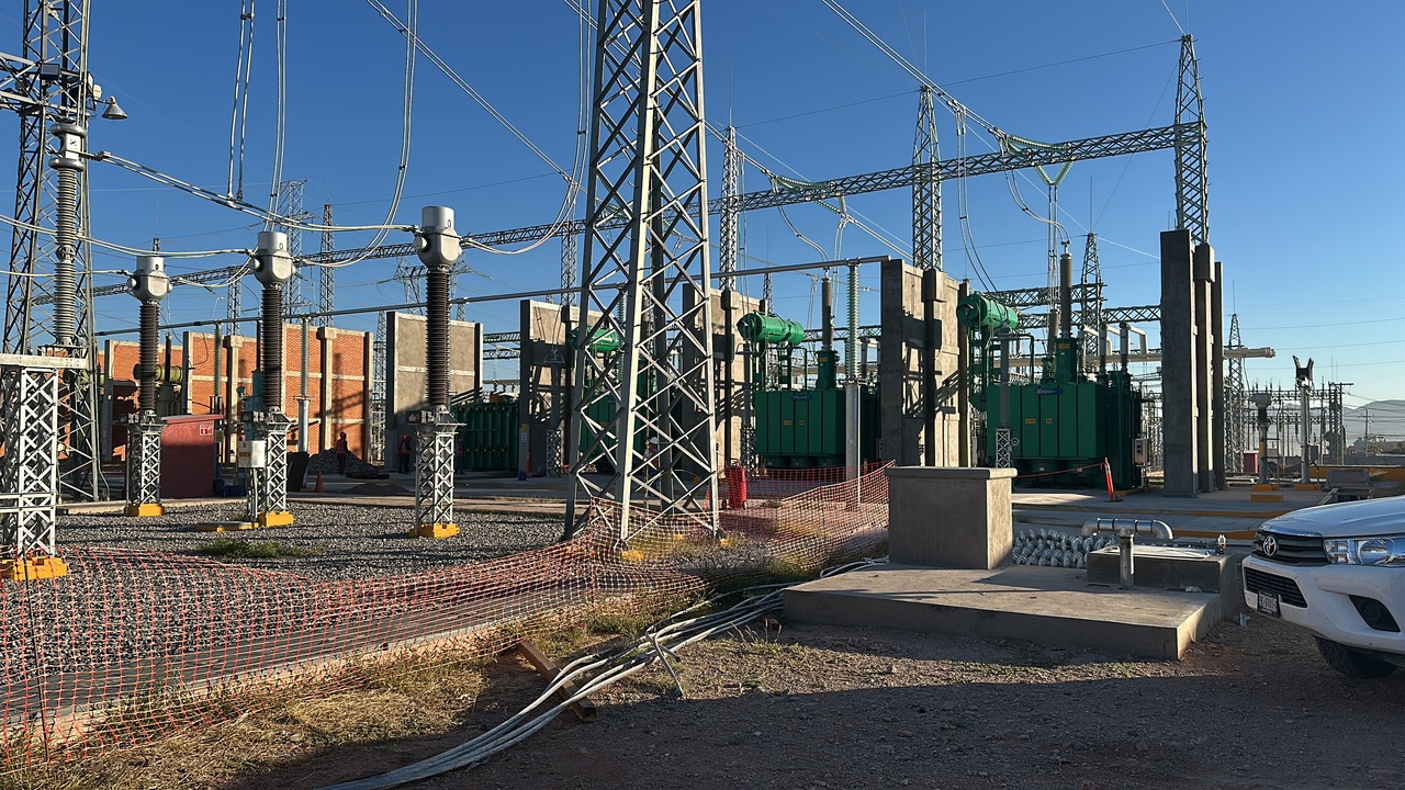 Interior de un centro de datos moderno y luminoso con estantes de servidores y techos altos.