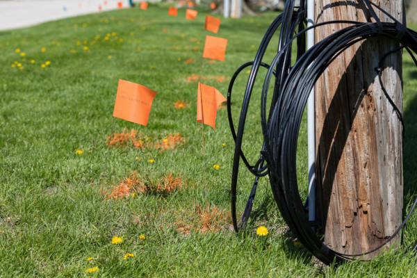 Fiber optic cable, orange marking flags and utility pole