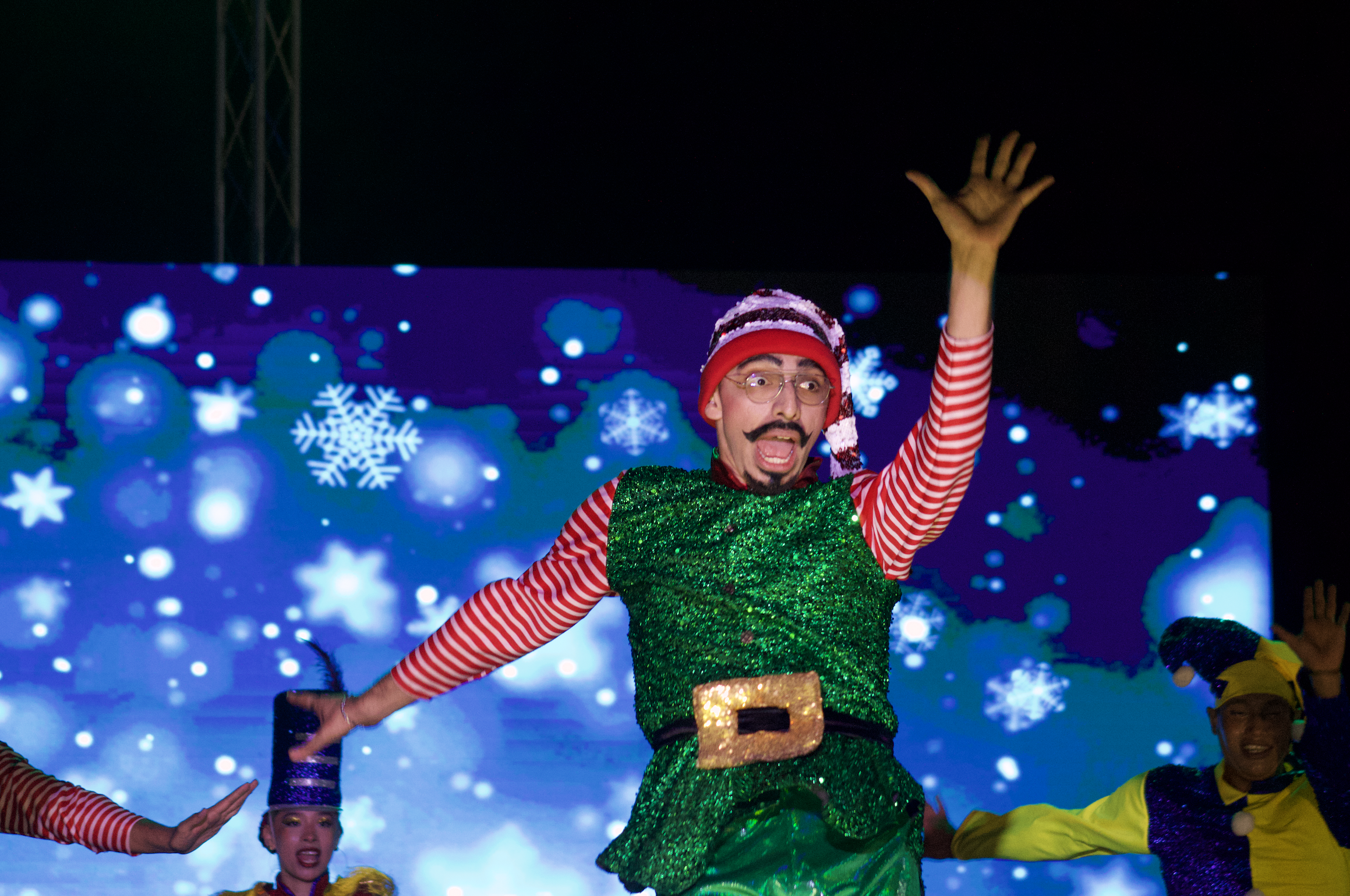Un grupo de cuatro niñas sonrientes con ropa de deporte, en un espacio interior con un cartel de fondo.