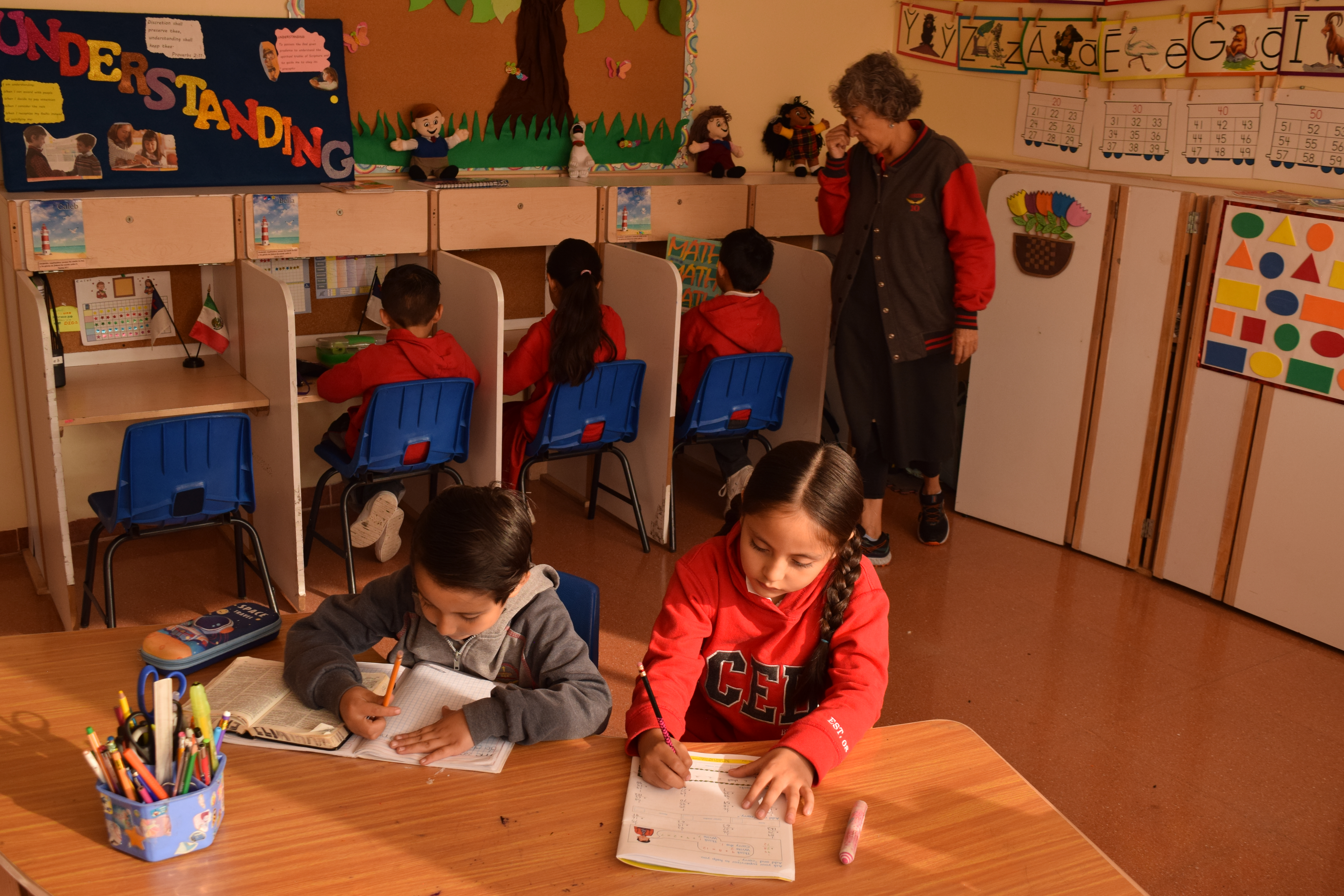 Happy child with glasses holding books and an apple on top Happy child with glasses holding books and an apple on top