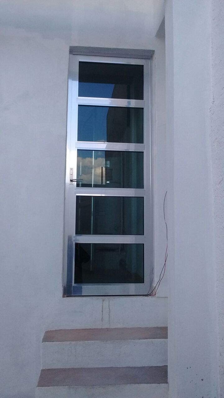 Puerta de vidrio y aluminio en tono brillante (línea española).