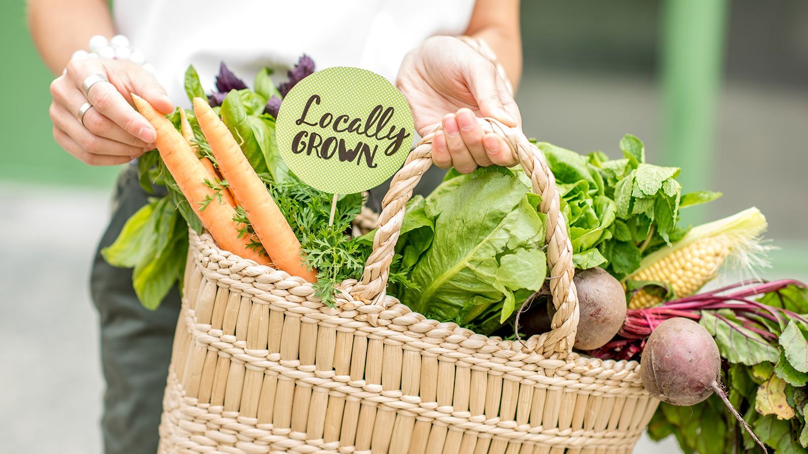 Holding Bag Full Of Fresh Organic Vegetables With Green Sticker